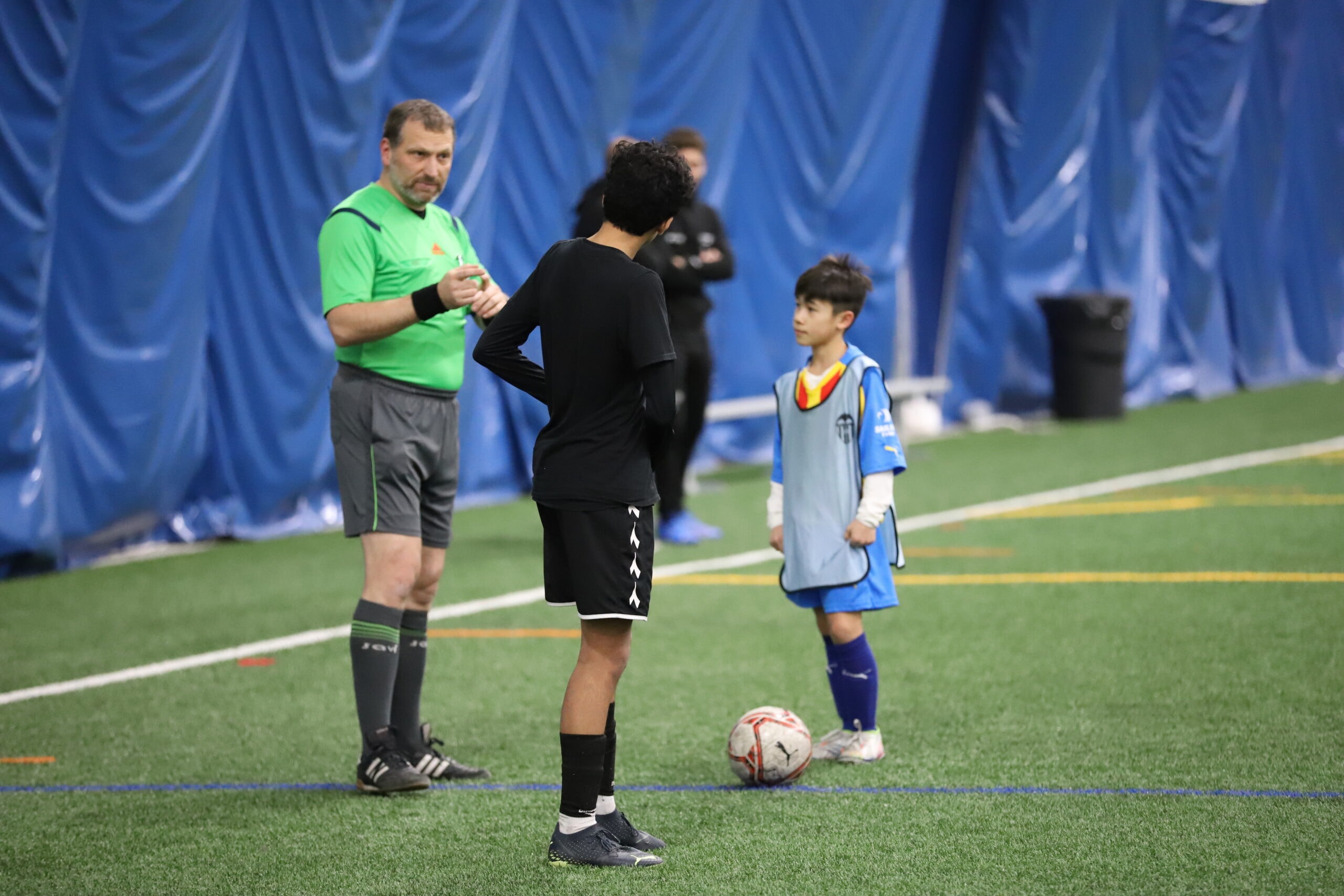 Arbitre avec des jeunes joueurs avant un match intérieur